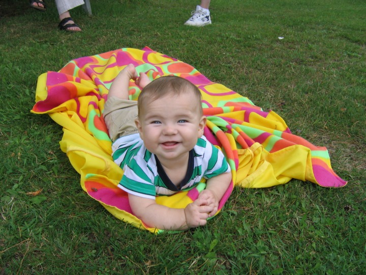 Arik smiling, lying on the grass